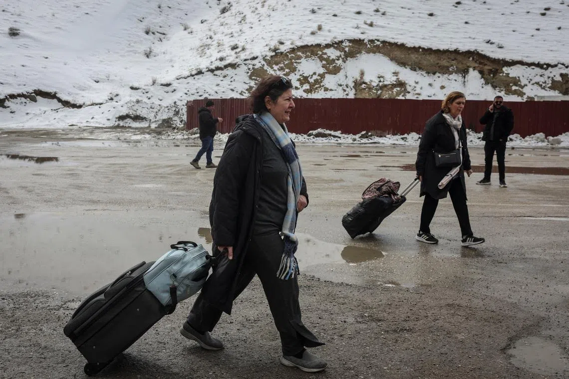 Ms Jalileh Jabari, 63, from Tehran, Iran, walks with a friend after crossing into Turkey, in Van province, Turkey, on March 5.