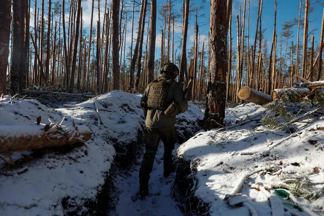 A Ukrainian serviceman walks in a trench at a front-line position near Kreminna, amid Russia's invasion of Ukraine.