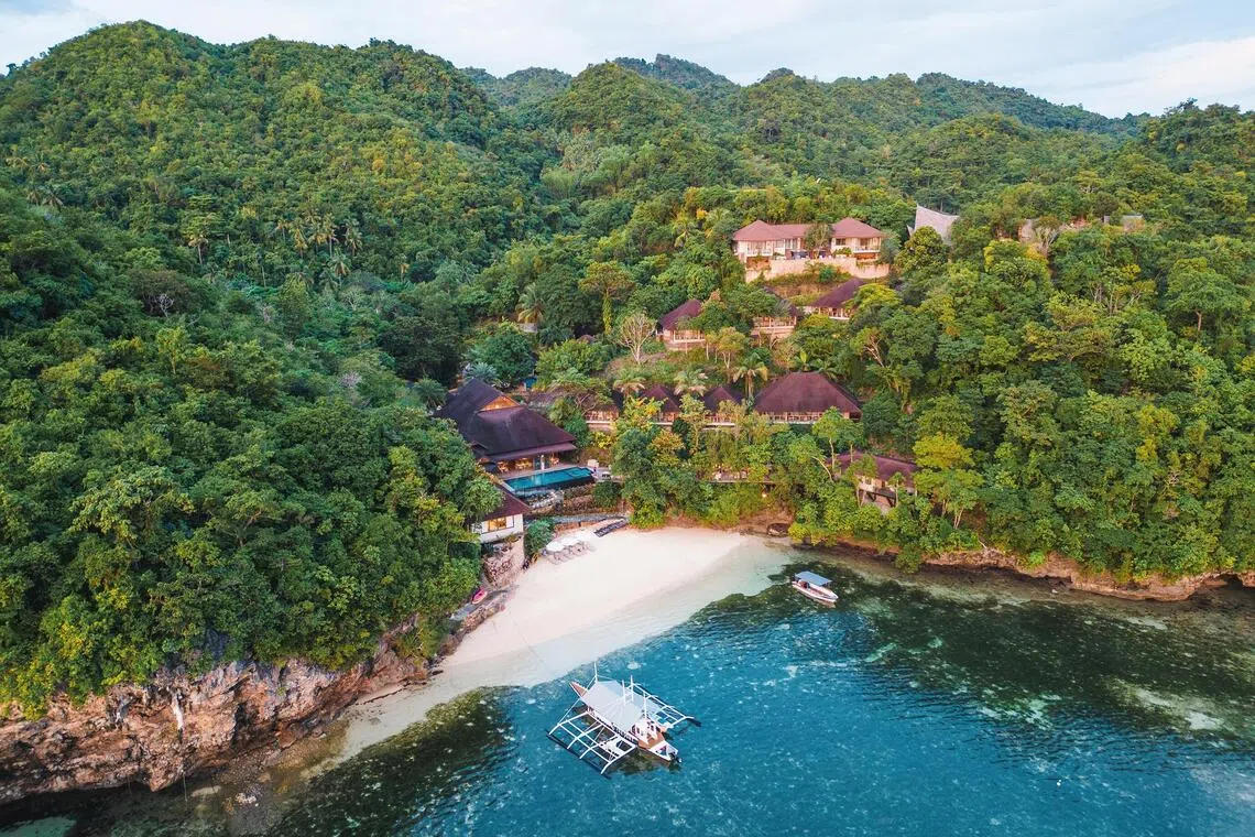 The private beach opens to a grassy seashore at Manami Resort.