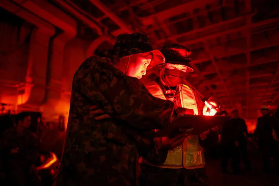 Hikari Maruyama, 38, and Runa Kurosawa, 20, soldiers with the Japanese Ground Self-Defense Force's Amphibious Rapid Deployment Brigade (ARDB), Japan's first marine unit since World War Two, take part in military training inside the Japanese Maritime Self-Defense Force's amphibious transport ship JS Osumi (LST-4001) in waters close to Okinawa, Japan, November 14, 2023. REUTERS/Issei Kato