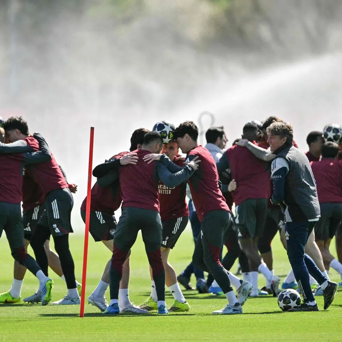 Arsenal players try to transport the ball without dropping it as they take part in a training session on the eve of their UEFA Champions League quarter-final, first-leg football match against Sporting in Portugal.