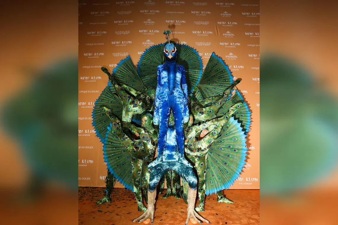 Heidi Klum dressed as a giant peacock with the help of Cirque du Soleil performers at the Marquee nightclub in New York, on Oct 31.