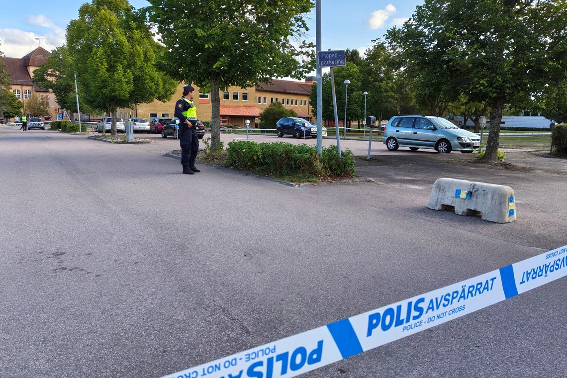 A police officer secures the site where several people were injured at a Swedish high school by a person armed with a sword on Aug 21.