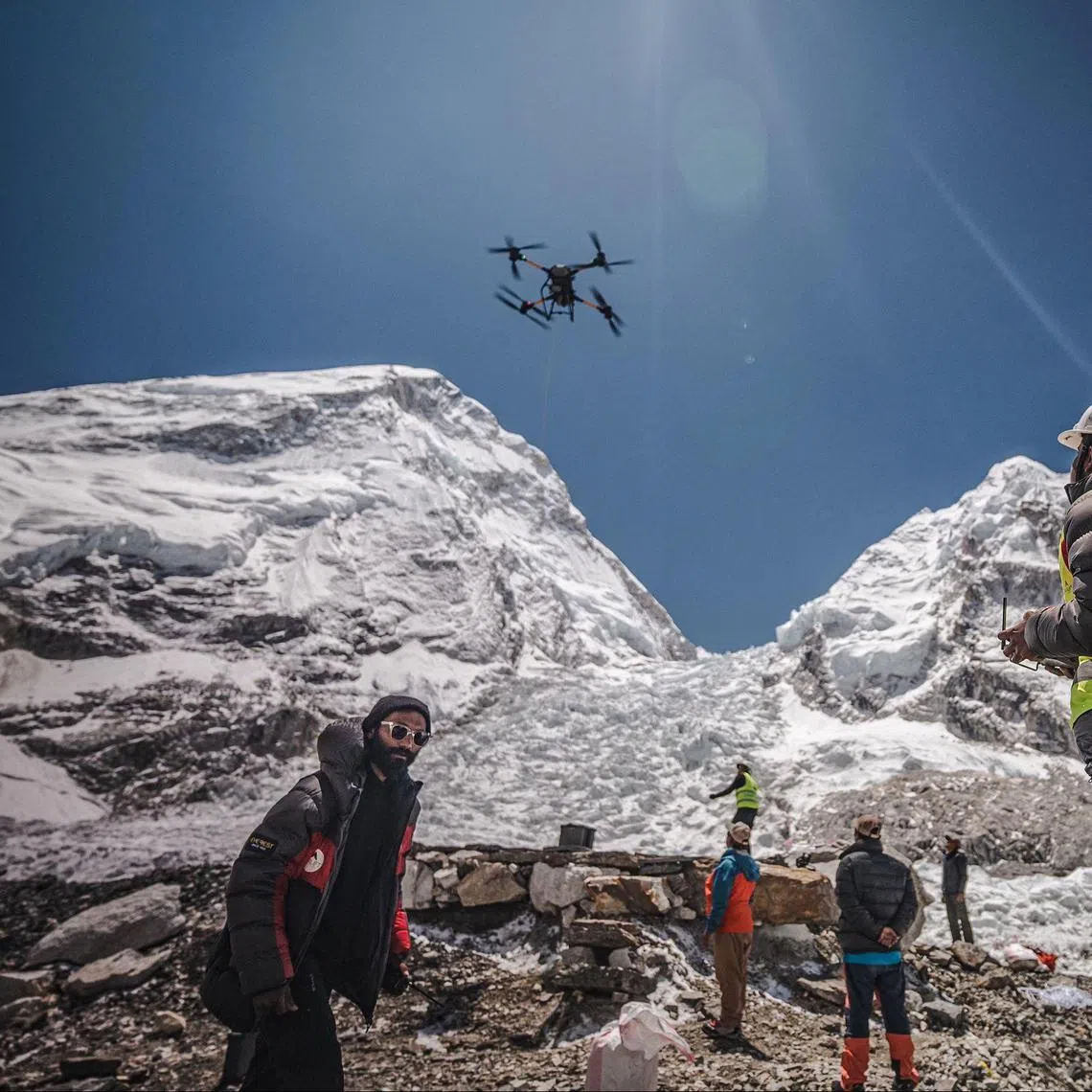 A man operates a heavy-lift drone to clear trash dumped at the Everest Base Camp.  