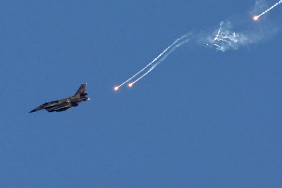 An Israeli fighter jet ejects flares over an area near the Lebanon-Israel border, as seen from northern Israel, on Aug 25, 2024. 