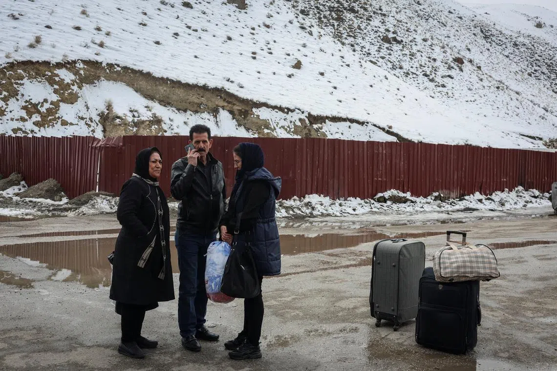 Yasna, 63, from Iran, stands with her husband and daughter after crossing into Turkey, in Van province, Turkey, on March 5.