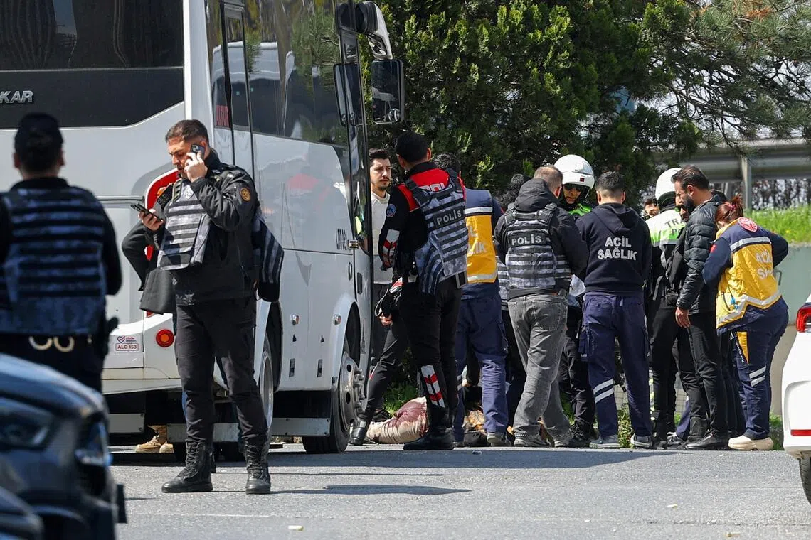 Police stand next to the body of a man believed to have fired shots outside Israel’s consulate in Istanbul.