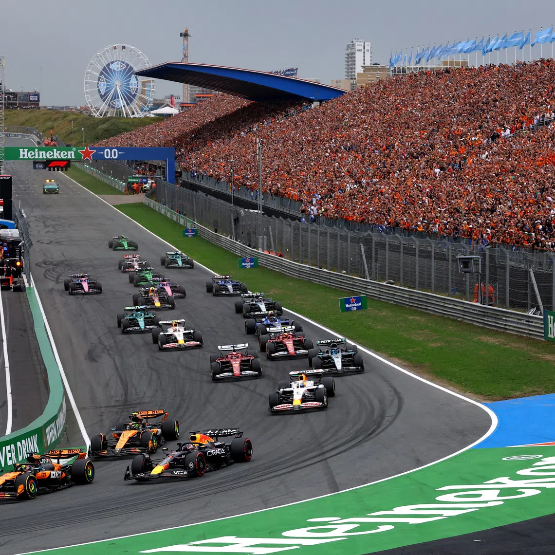 FILE PHOTO: Formula One F1 - Dutch Grand Prix - Circuit Zandvoort, Zandvoort, Netherlands - August 31, 2025 McLaren's Oscar Piastri leads into the first corner at the start of the race ahead of McLaren's Lando Norris and Red Bull's Max Verstappen REUTERS/Piroschka Van De Wouw/File Photo