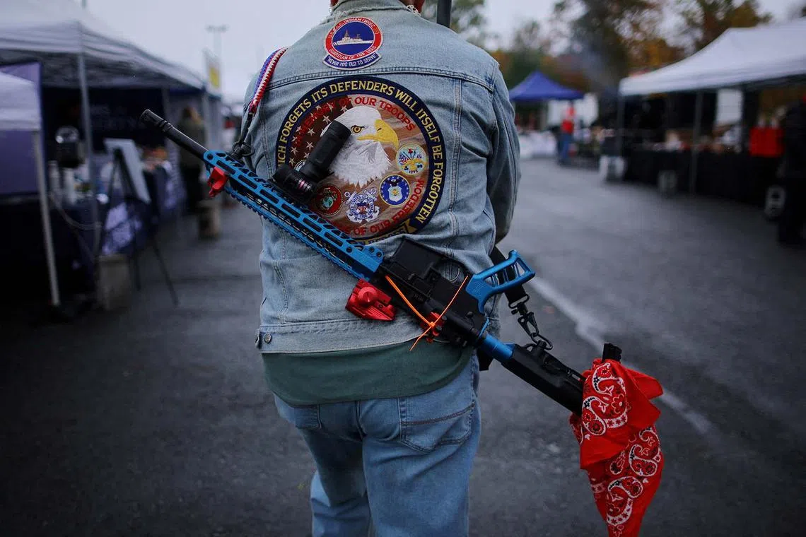 An attendee carries a rifle at the Rod of Iron Freedom Festival, which the organizers call "the largest open carry rally in America," in Greeley, Pennsylvania, U.S., October 13, 2024. REUTERS/Brian Snyder TPX IMAGES OF THE DAY