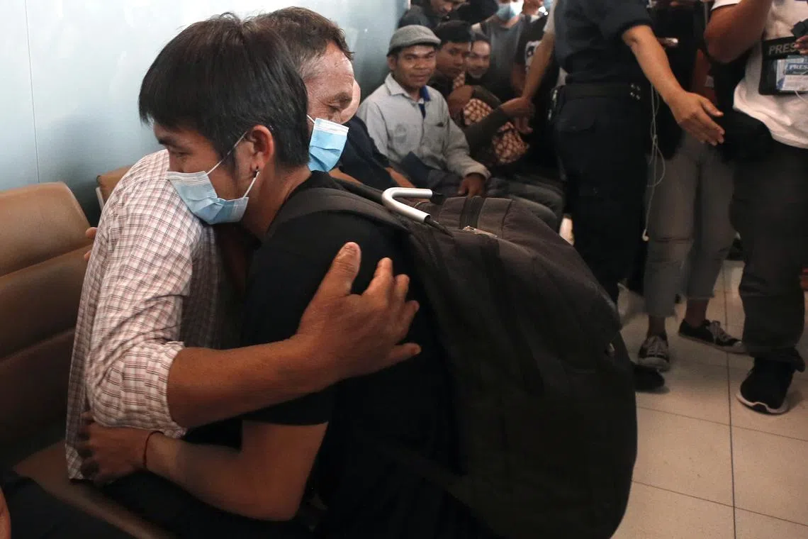 A Thai worker (right) evacuated from Israel hugs his father after arriving at Suvarnabhumi Airport.