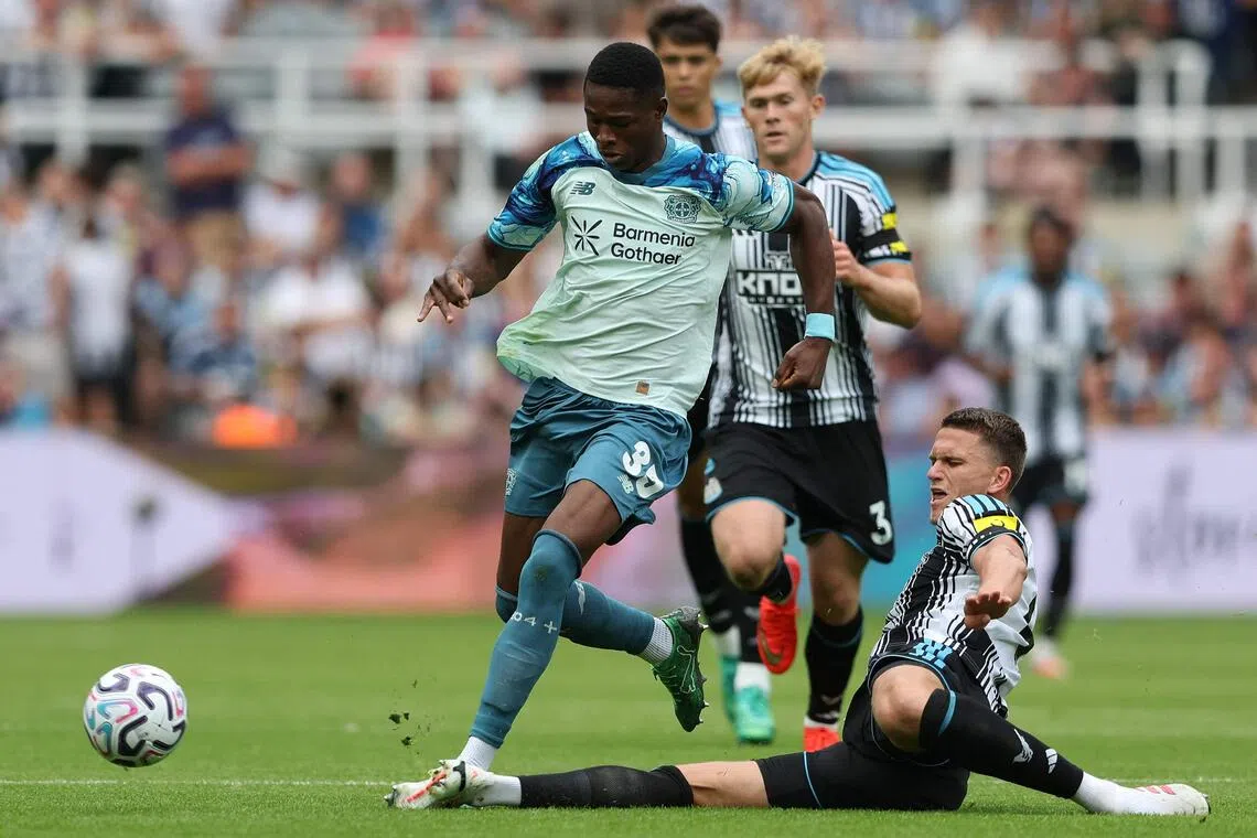 Newcastle United defender Sven Botman (right) tackling Bayer Leverkusen striker Christian Kofane before Newcastle changed their kit.