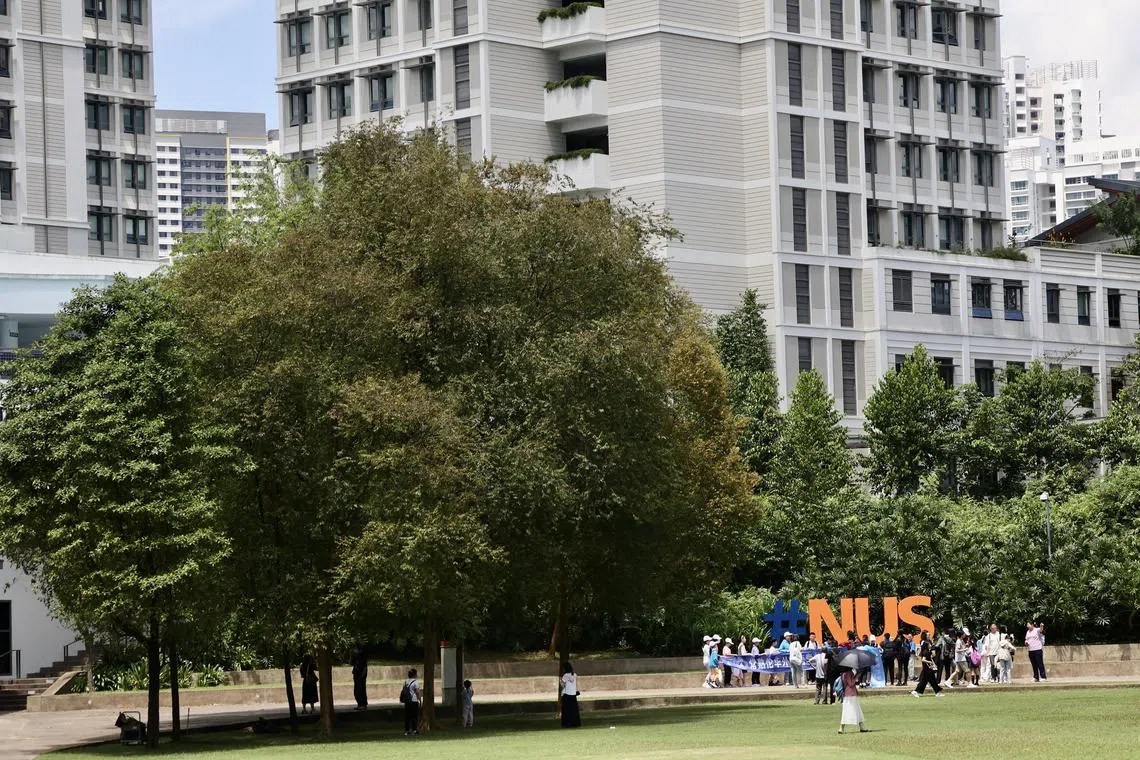 A tour group posing for photographs at University Town at National University of Singapore.