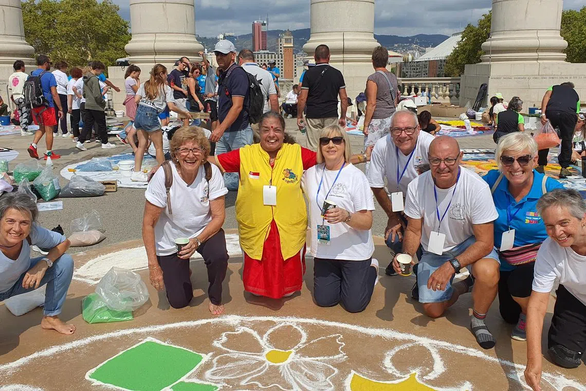 A large rangoli showing a range of flowers including chrysanthemum and gerbera in Barcelona in Spain. Mrs Vijaya Mohan is at centre. 