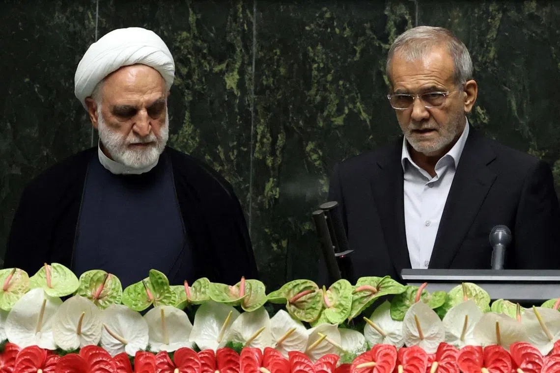 New Iranian President Masoud Pezeshkian (right) is sworn in by  Iranian judiciary chief Gholam Hossein Mohseni Ejeie, on July 30.