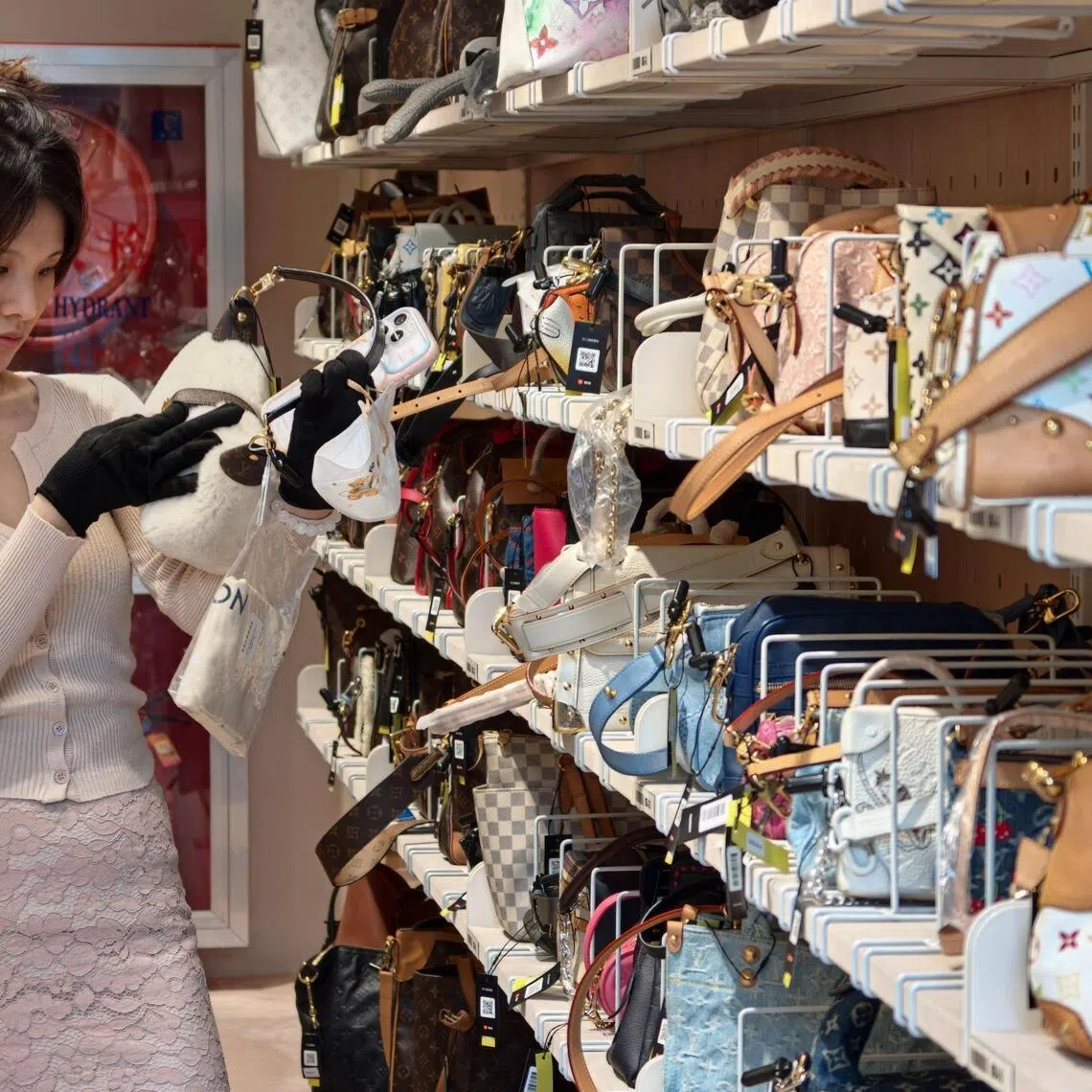 A customer browsing purses among second-hand luxury goods at the Zhuanzhuan superstore in Shanghai on Oct 14.
