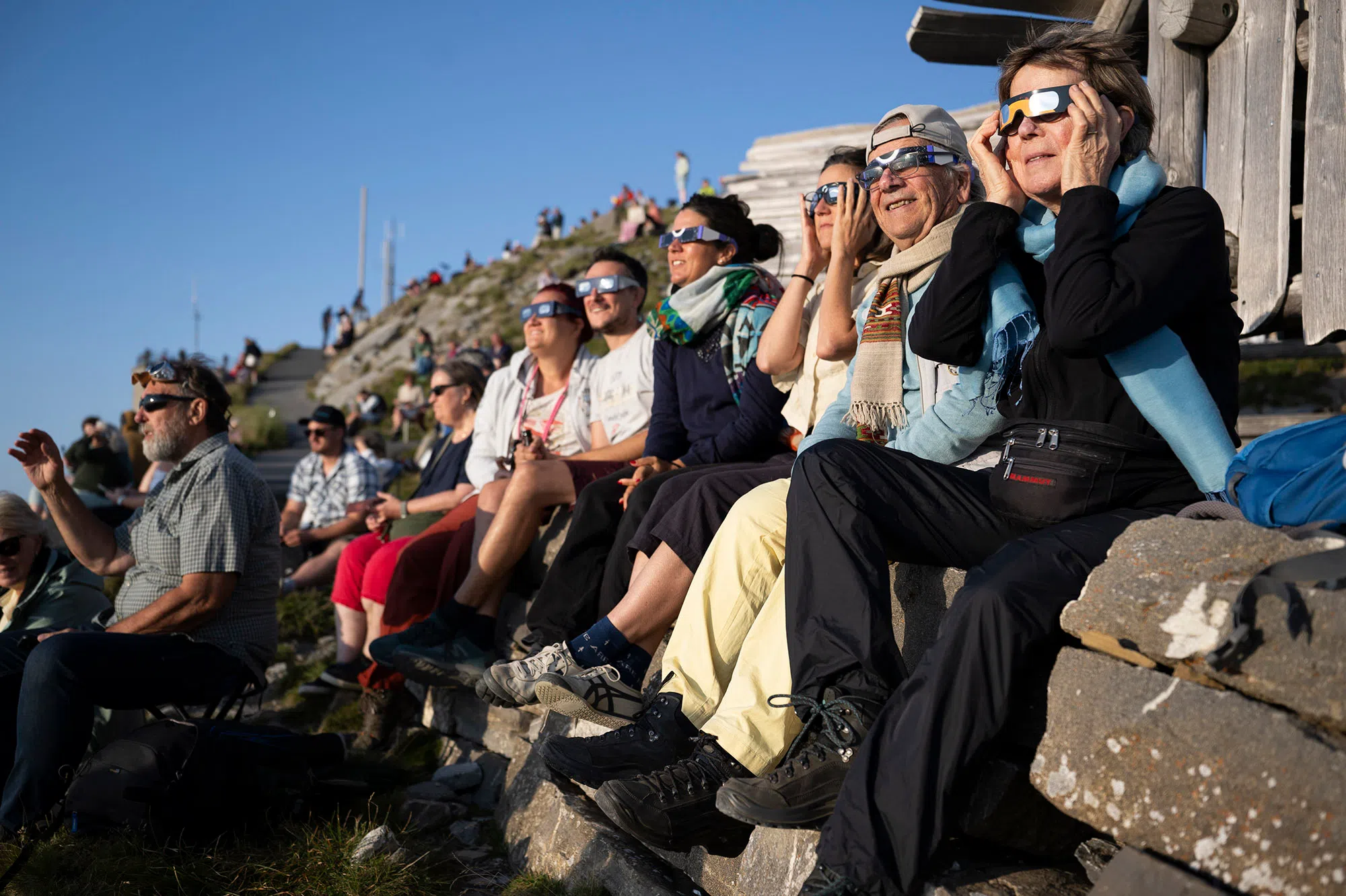 epa13164866 People observe the Moon obscures the Sun during a partial solar eclipse from the summit of Niesen in the Bernese Oberland, Switzerland, 12 August 2026. A total solar eclipse will sweep across parts of Europe and the North Atlantic on 12 August, with the path of totality moving through Greenland, Iceland, Spain, and a small section of northeastern Portugal, while surrounding areas across Europe experience a partial solar eclipse, according to the European Space Agency (ESA). EPA/ANTHONY ANEX