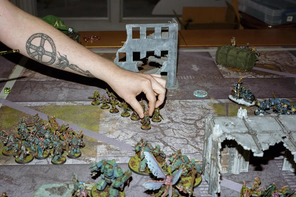 FILE — A player set a piece at a tabletop game Warhammer 40,000 in New York, on Dec. 20, 2021. Games Workshop, the company behind Warhammer 40,000, the wildly popular tabletop game with miniature figurines, announced on Monday, Dec. 18, 2023, that it had reached a deal with Amazon Studios to bring the game to life on television and film screens. (Camilo Fuentealba/The New York Times)