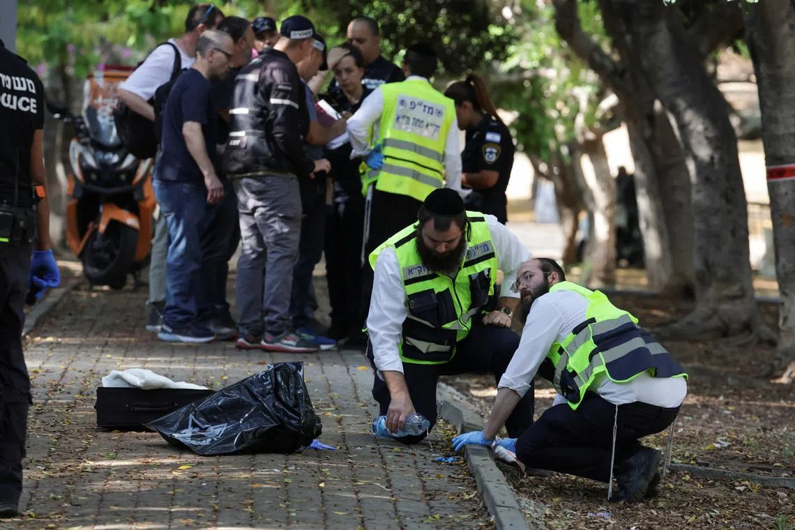 Israeli emergency responders work at the scene of a suspected stabbing attack in Holon, Israel, August 4, 2024. REUTERS/Ricardo Moraes