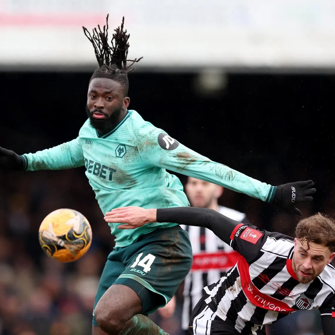 Soccer Football -  FA Cup - Fourth Round - Grimsby Town v Wolverhampton Wanderers - Blundell Park, Cleethorpes, Britain - February 15, 2026 Wolverhampton Wanderers' Tolu Arokodare in action with Grimsby Town's Jamie Walker REUTERS/Scott Heppell