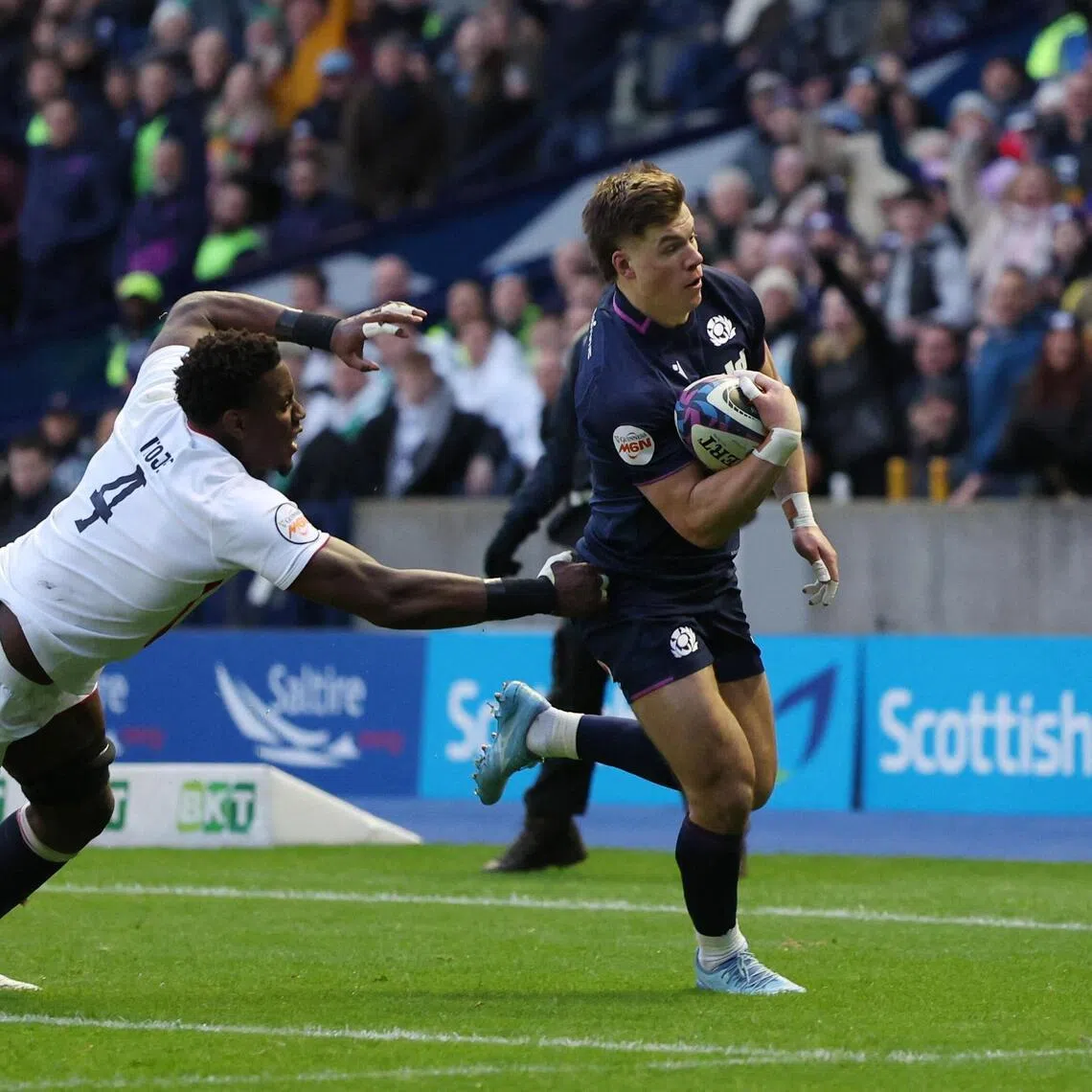 Huw Jones evading England captain Maro Itoje to score the first try in Scotland's 31-20 Six Nations home win at Murrayfield in Edinburgh on Feb 14, 2026
.