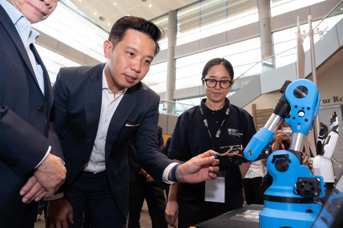 Minister of State for Trade and Industry Alvin Tan checking out a robot gripper at the lab launch on June 7, 2023. With him is Dr Cindy Tang, a research fellow at NTU.