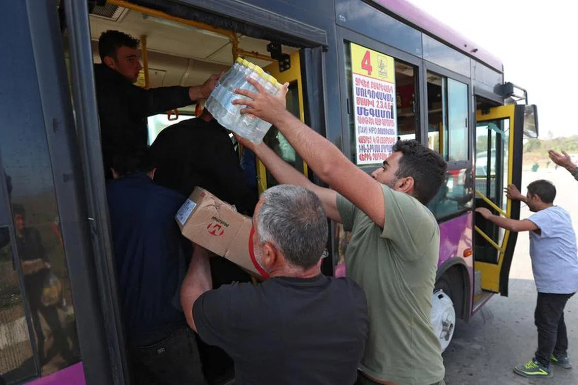 Volunteers give water and food to refugees from Nagorno-Karabakh region arriving in the border village of Kornidzor, Armenia, September 29, 2023. REUTERS/Irakli Gedenidze
