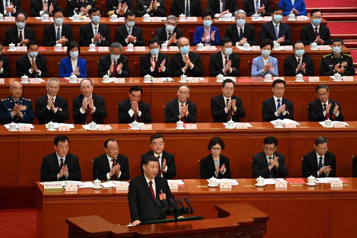 China's President Xi Jinping (front) speaks during the closing session of the National People's Congress at the Great Hall of the People in Beijing, on March 13, 2023. 