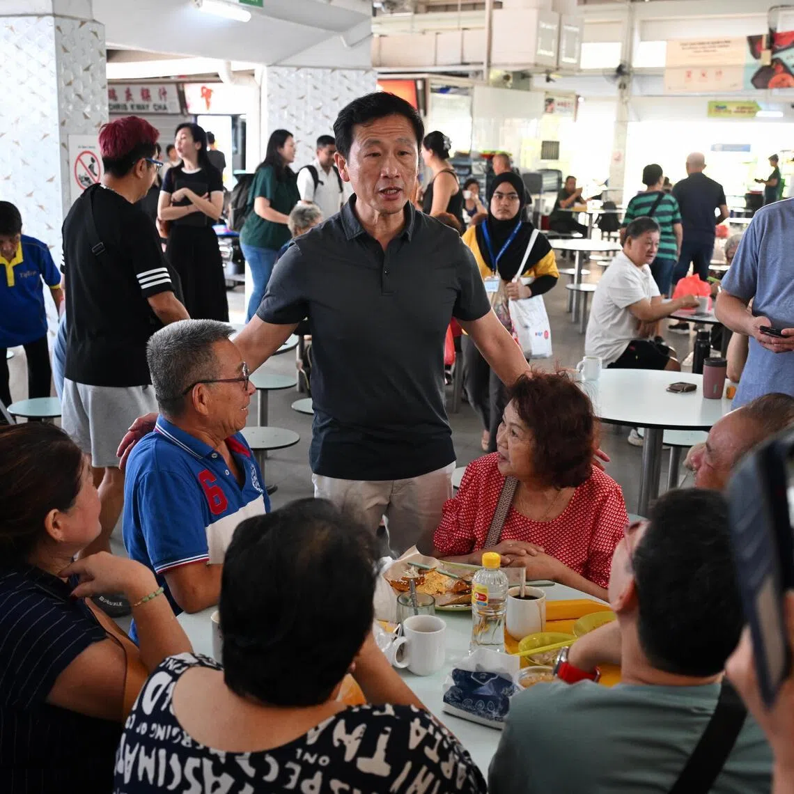 Health Minister Ong Ye Kung (centre) speaking to patrons at Block 216 Bedok Food Centre, one of three locations linked to several TB cases. 