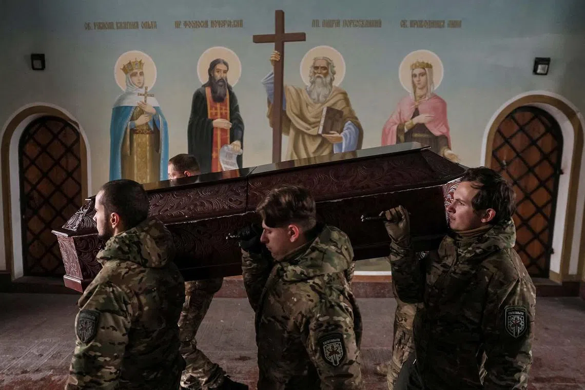 Members of the Ukrainian volunteer paramedic organization Hospitallers carry a coffin with the body of one of the organization's members, a Swedish citizen nicknamed Niko, 20, who was killed near Bakhmut amid Russia's attack on Ukraine, after a memorial service in Mikhailovsky Zlatoverkhy Cathedral (St. Michael's Golden-Domed Cathedral) in central Kyiv, Ukraine December 13, 2022. REUTERS/Gleb Garanich TPX IMAGES OF THE DAY