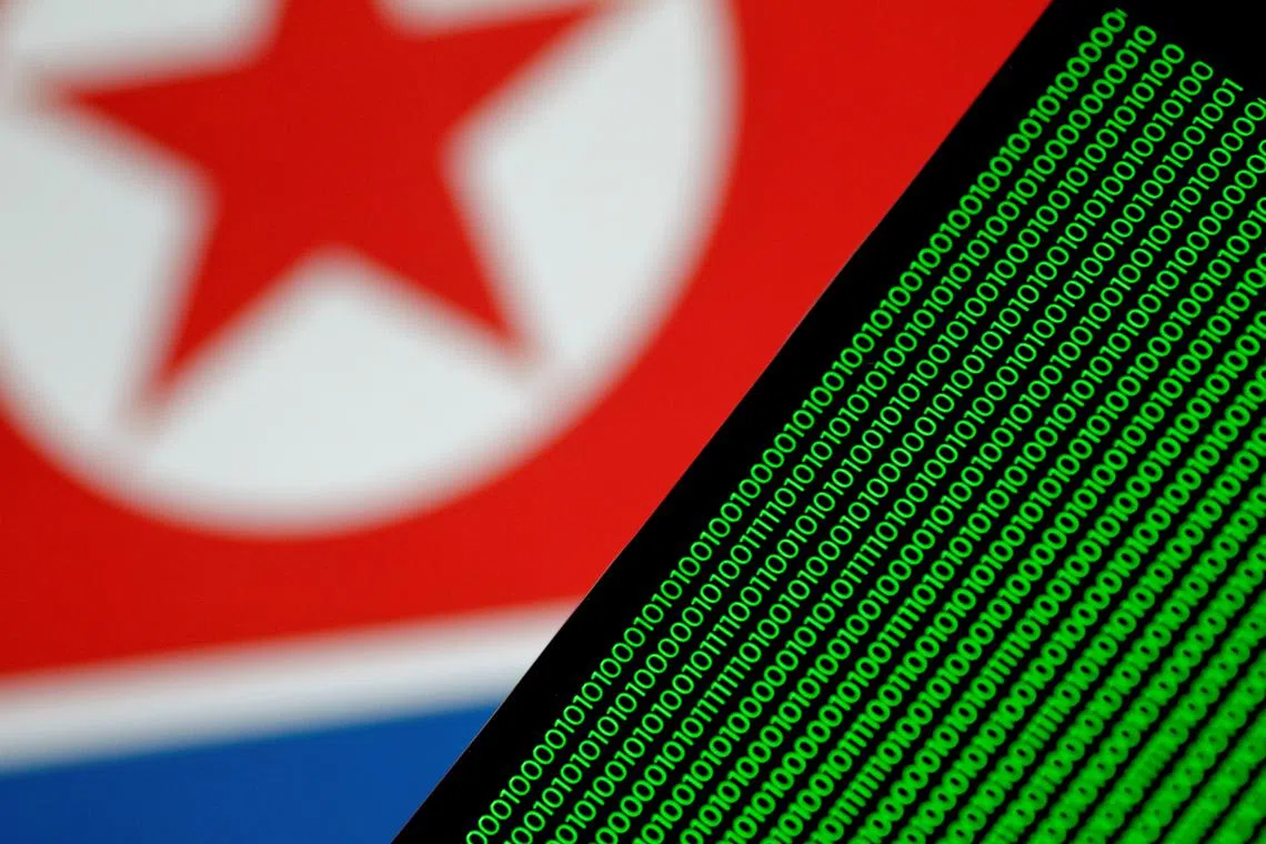 FILE PHOTO: Binary code is seen on a screen against a North Korean flag in this illustration photo November 1, 2017. REUTERS/Thomas White/Illustration/File Photo