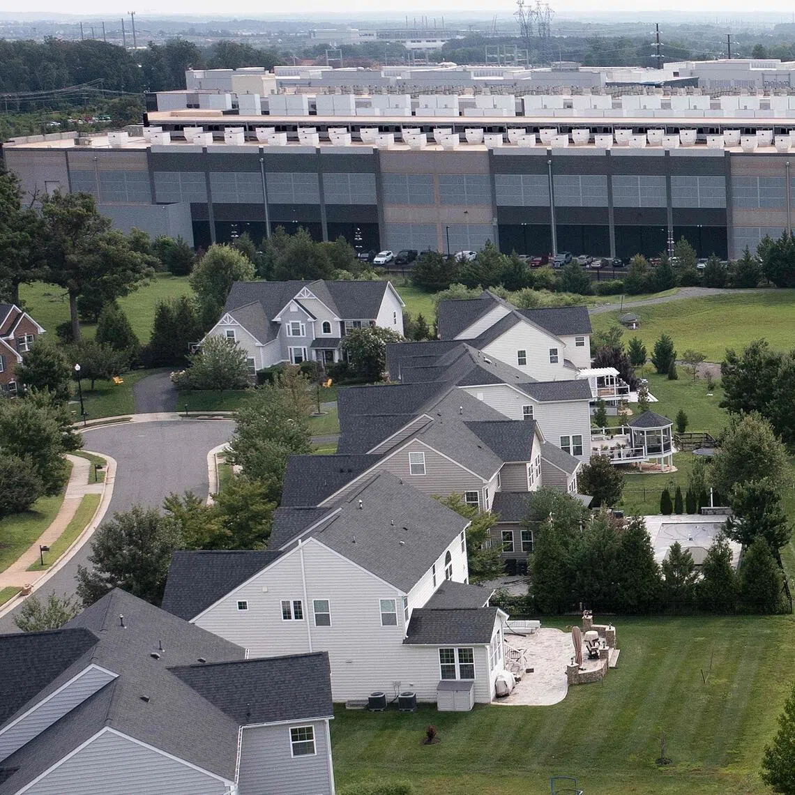 An Amazon Web Services data centre adjacent to single-family homes in Stone Ridge, Virginia, US. Tech giants are seeking to win over residents increasingly hostile to an AI-driven data centre construction boom.