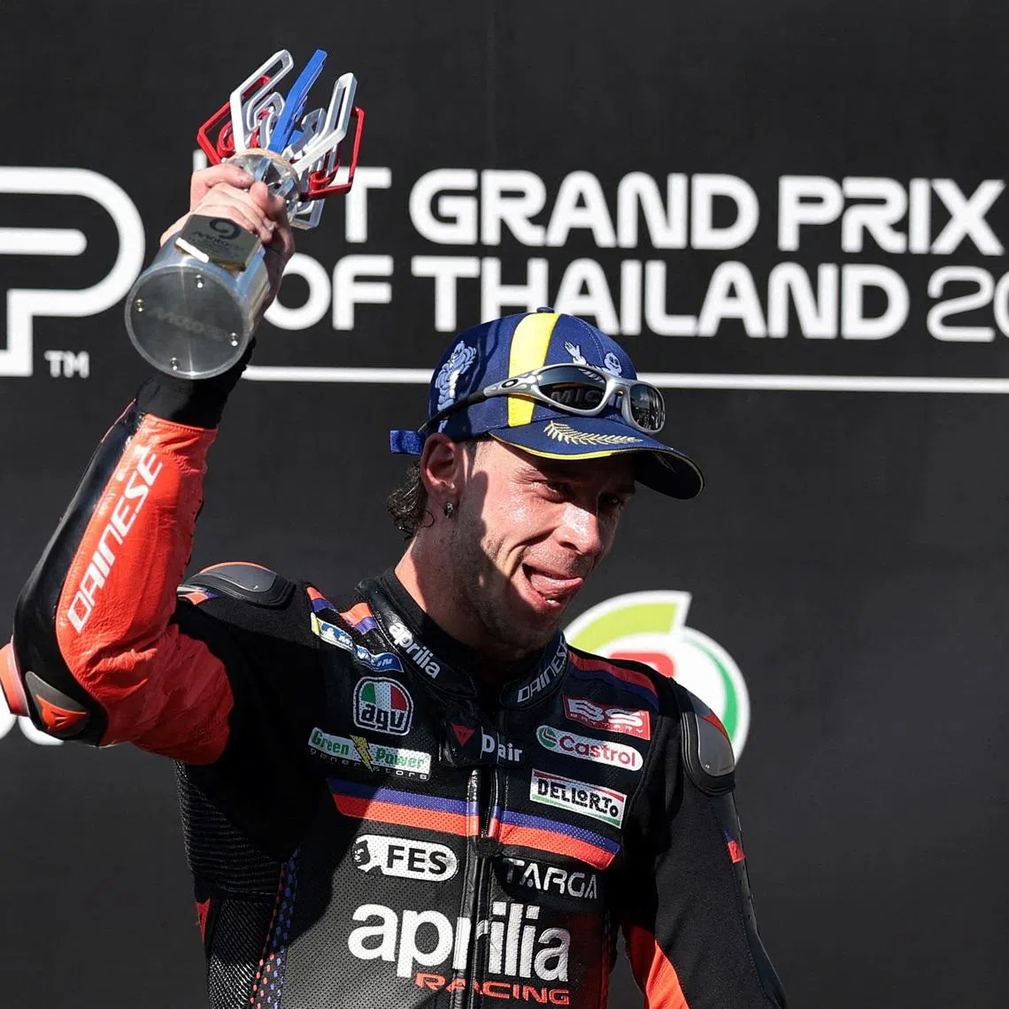 MotoGP - Thailand Grand Prix - Chang International Circuit, Buriram, Thailand - March 1, 2026 Aprilia Racing's Marco Bezzecchi celebrates winning the MotoGP race on the podium with the trophy REUTERS/Chalinee Thirasupa