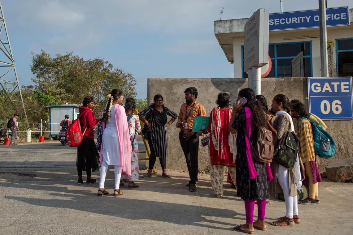 Job aspirants talk with a hiring agent outside the Foxconn factory, where workers assemble iPhones for Apple, in Sriperumbudur, near Chennai, India, April 1, 2024.  REUTERS/Palani Kumar
