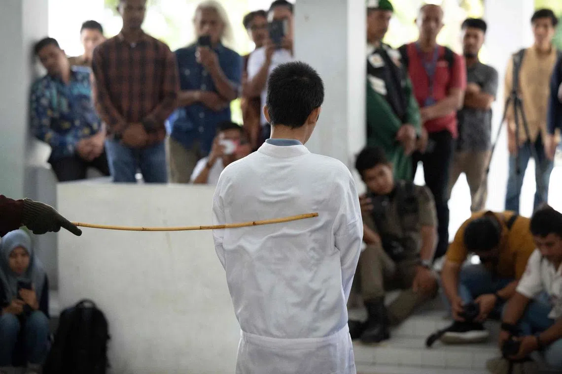 The men were caned with a rattan stick as dozens watched on.