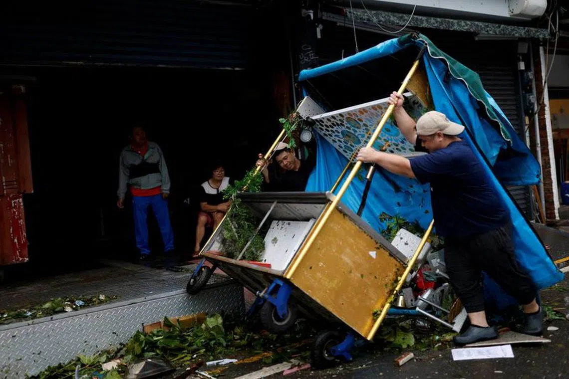 FILE PHOTO: Workers lift up a turned-over food cart after Typhoon Koinu passed the southern tip of Taiwan, in Kenting, Taiwan October 5, 2023. REUTERS/Carlos Garcia Rawlins/File Photo