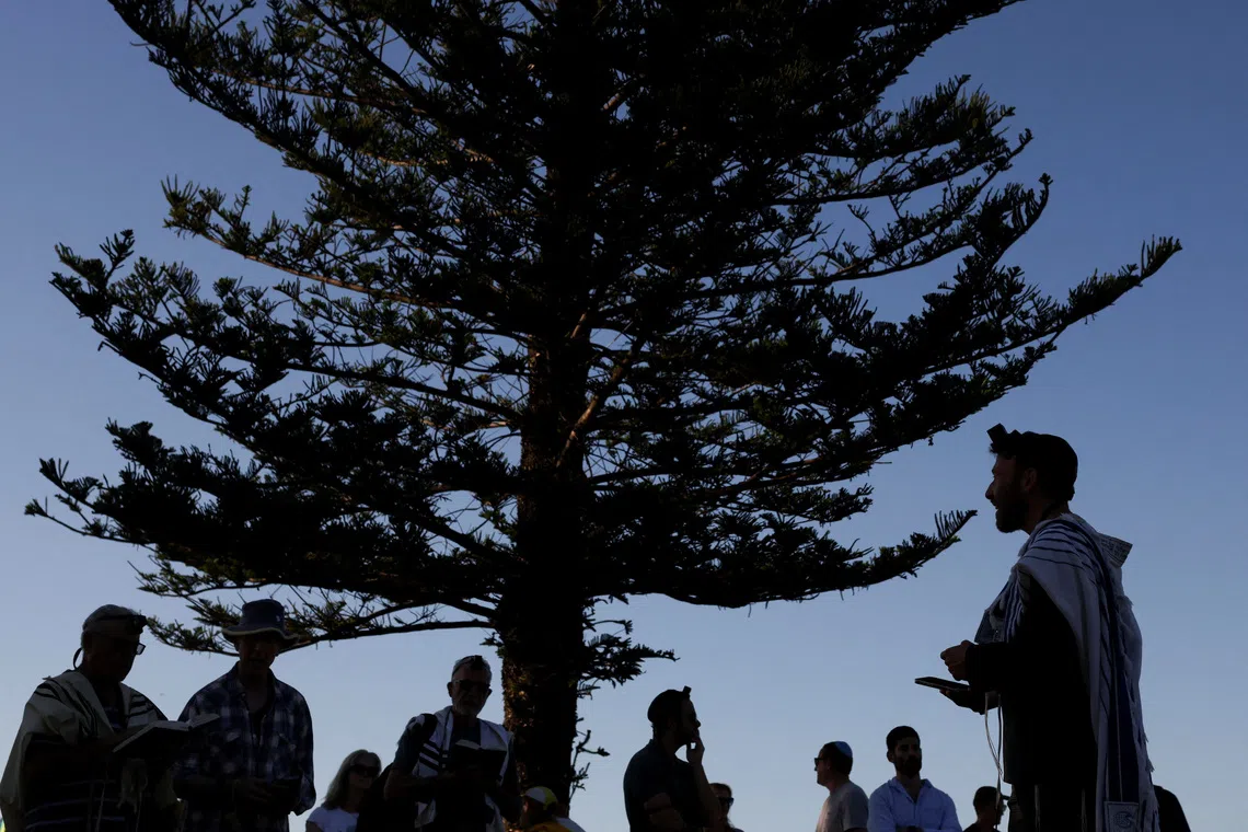 Members of the Jewish community gathering for morning prayers, as the beach was reopened following the mass shooting at Bondi Beach on Sunday, in Sydney, Australia, Dec 19, 2025. 