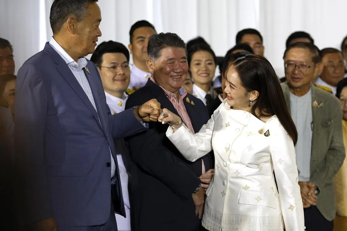 Thailand's Prime Minister Paetongtarn Shinawatra greets the dismissed former prime minister Srettha Thavisin after the royal command endorsement ceremony at Pheu Thai Party's headquarters.