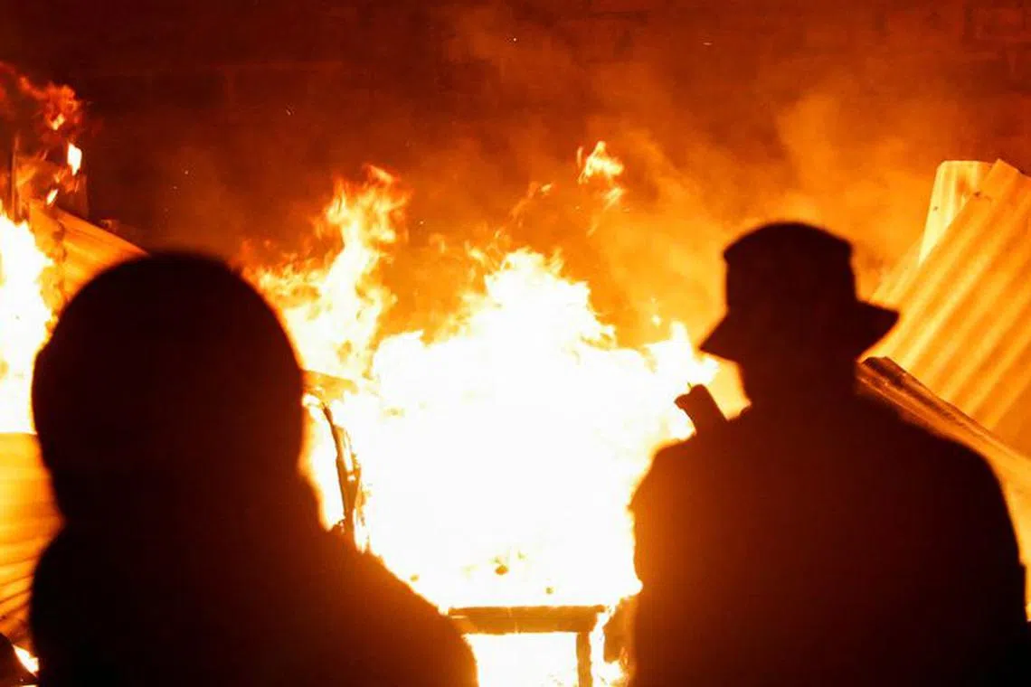 Residents gather at the scene of an explosion at a makeshift gas cylinder refilling depot in Mradi estate, Embakasi district, in Nairobi, Kenya, February 2, 2024. REUTERS/Thomas Mukoya