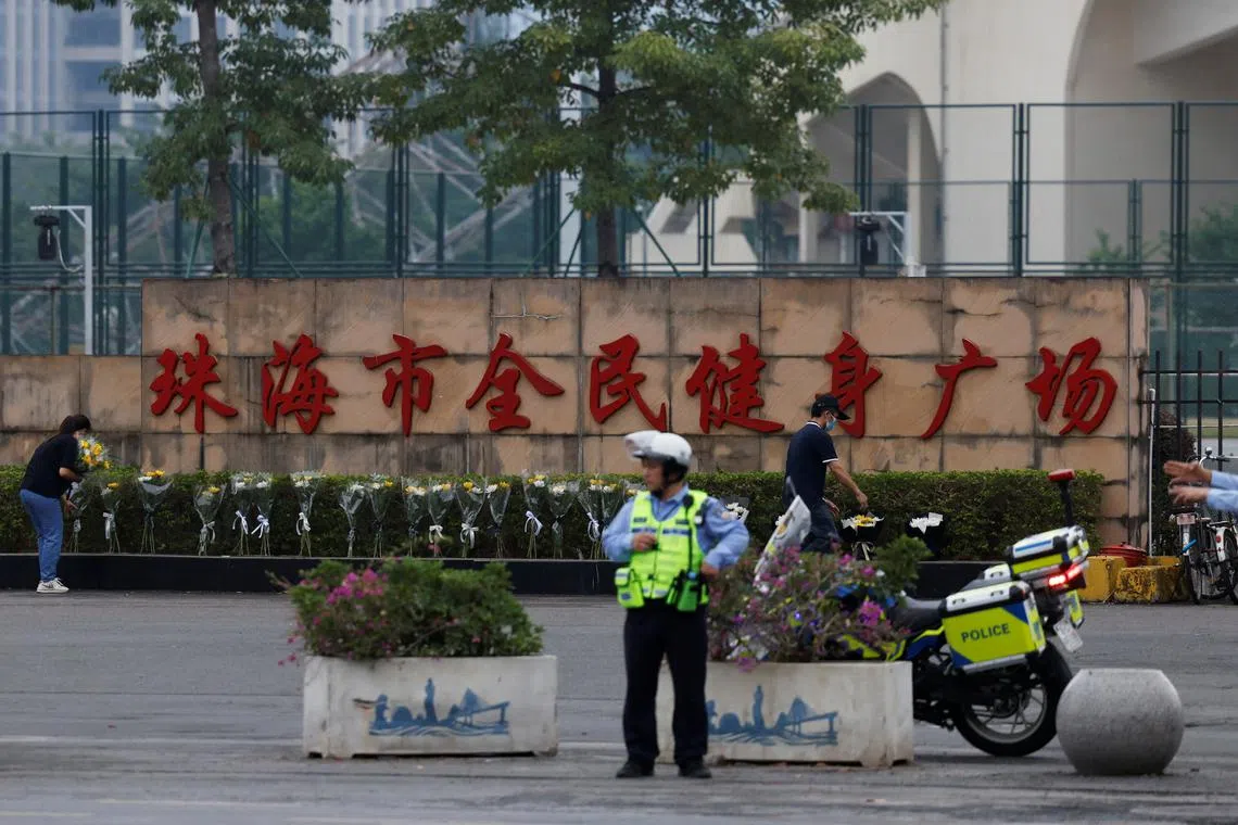 A police officer keeps watch as people remove flower bouquets placed outside the sports centre where a deadly car attack took place, in Zhuhai, Guangdong province, China November 13, 2024. REUTERS/Tingshu Wang/File Photo