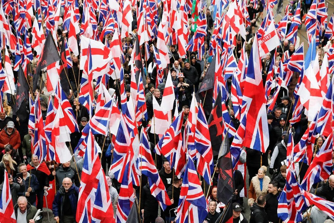 People hold Union Jack flags as they take part in a Britain First "March for Remigration" in Manchester, Britain, on Feb 21, 2026.