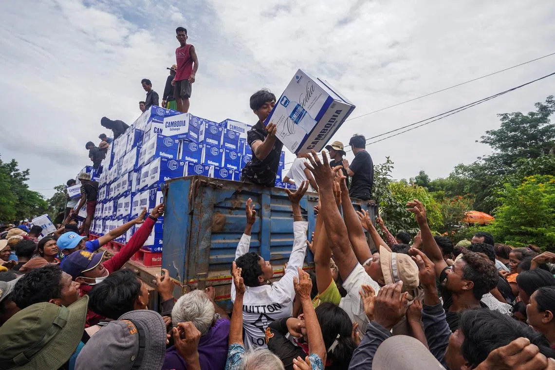 People gather to receive water supplies donated at Batthkao Primary School camp, amid ongoing clashes on the Thai-Cambodian border that extended to the third day, with new flashpoints emerging as both sides seek diplomatic support and urge for negotiations, in Oddar Meanchey province, Cambodia, July 26, 2025. REUTERS/Soveit Yarn