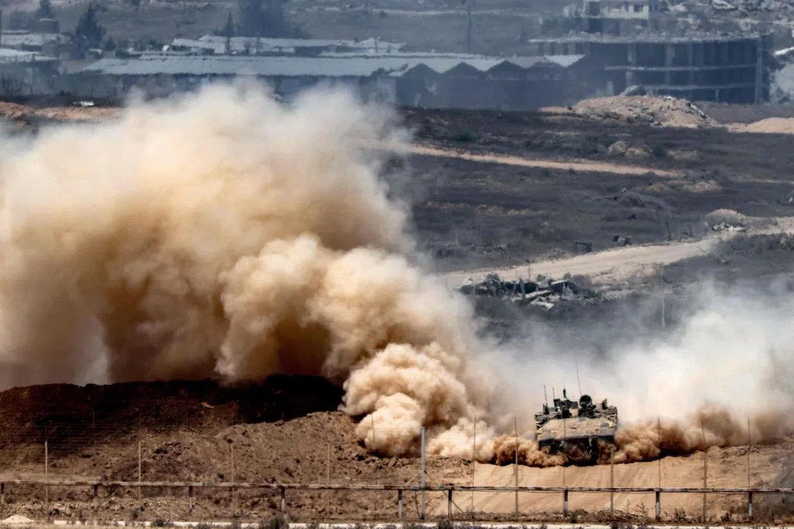 An Israeli army infantry-fighting vehicle  leaves a cloud of dust as it moves at a position along Israel's southern border with the Gaza Strip on Aug 5, 2025.