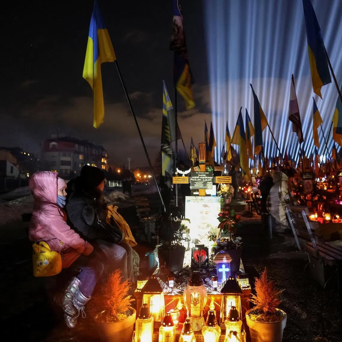 People visit the graves of their relatives killed in the four-year war sparked by Russia's invasion of Ukraine.