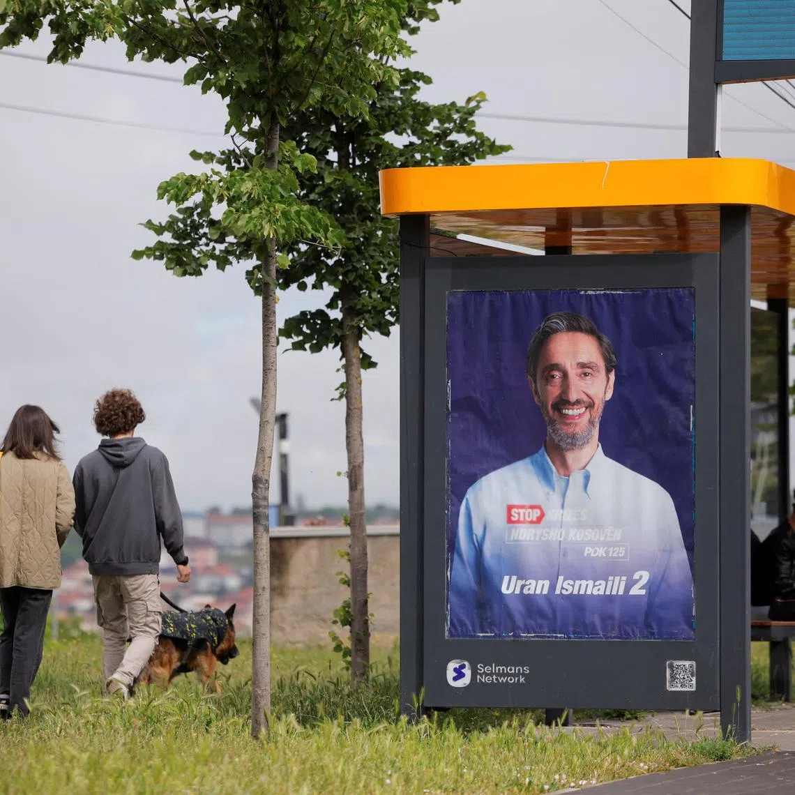 People walk past an election poster of the Democratic Party of Kosovo (PDK) in Pristina, Kosovo, June 4, 2026. Kosovo is to hold a snap parliamentary election, the third in just over a year, after parliament failed to elect a new head of state. REUTERS/Valdrin Xhemaj