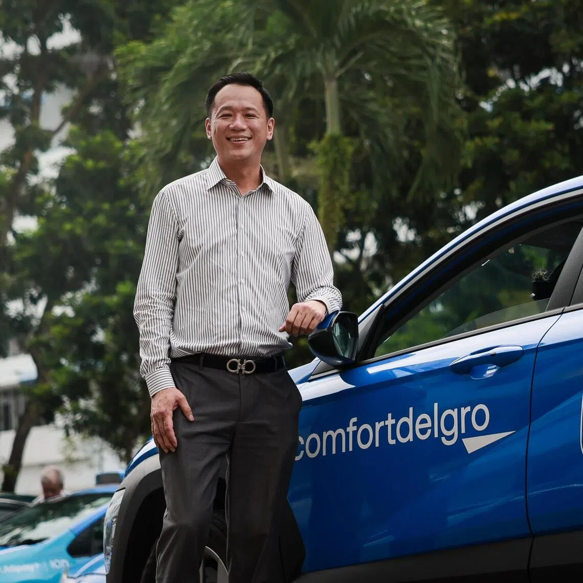 ComfortDelGro's head of point-to-point mobility business in Singapore Michael Huang with the company’s redesigned logo on the side of a taxi at Comfort Transportation at Sin Ming Drive on Sep 22, 2025.