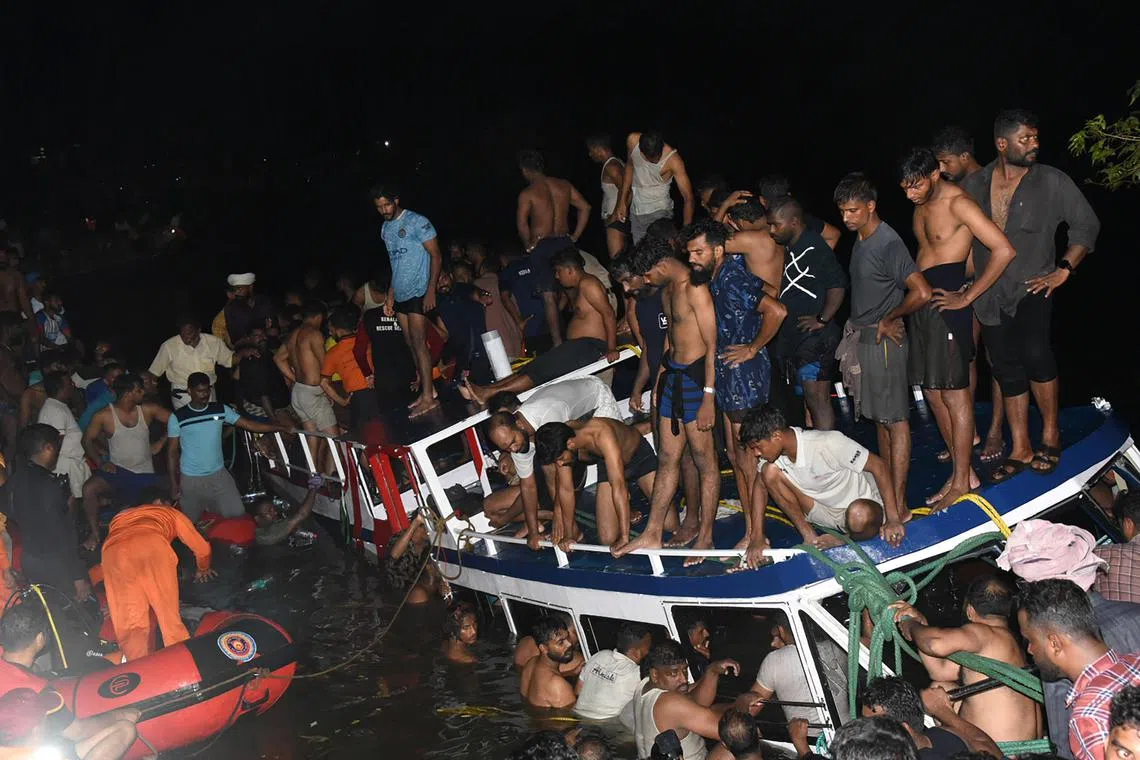 In this photograph taken on May 7, 2023, people carrying out rescue operation at the site of a boat accident in Tanur, in Malappuram district of India's Kerala state. At least 20 people died when a double-decker tourist boat capsized in India's southern state of Kerala late on May 7, 2023