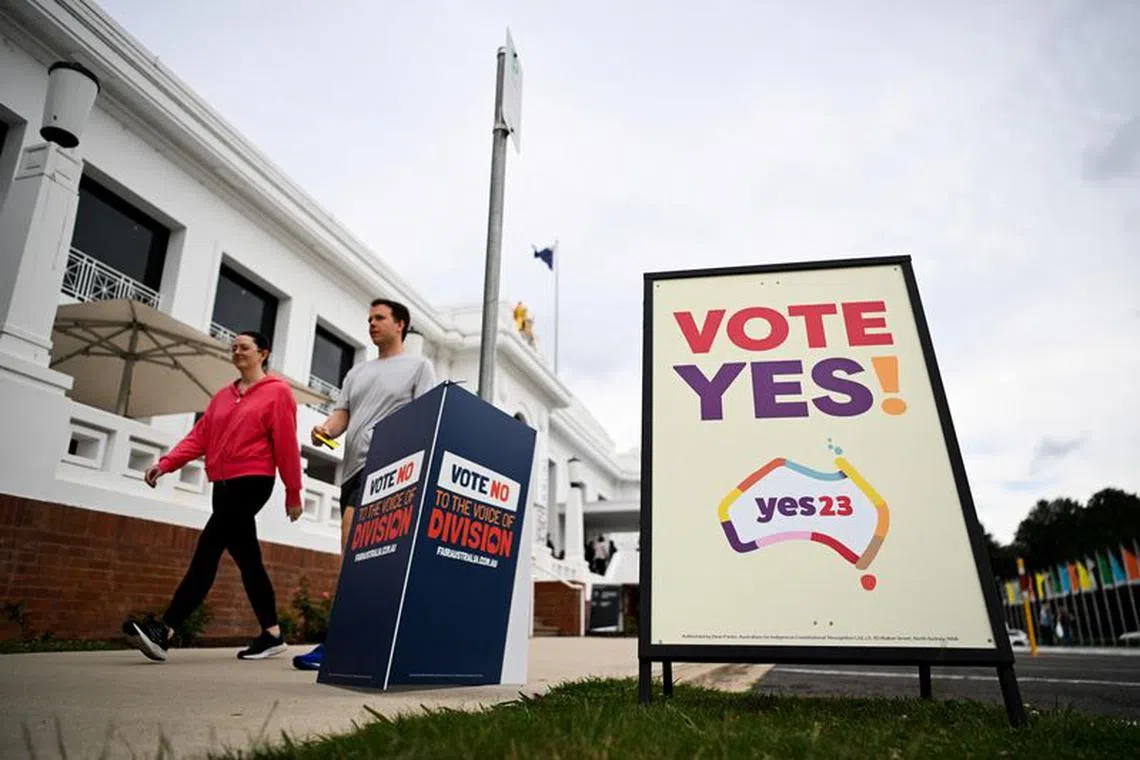 Voters walk past Vote 'Yes' and Vote 'No' signs at the Old Australian Parliament House, during The Voice referendum in Canberra, Australia, October 14, 2023. REUTERS/Tracey Nearmy