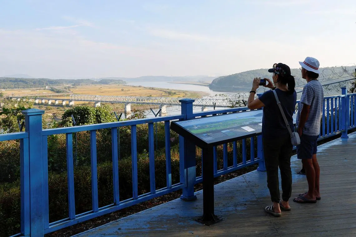 A visitor takes a picture of the Bridge of Freedom, which connects North Korea and South Korea, at the Imjingak pavilion near the demilitarized zone which separates the two Koreas, in Paju, South Korea, October 16, 2024. REUTERS/Kim Soo-hyeon