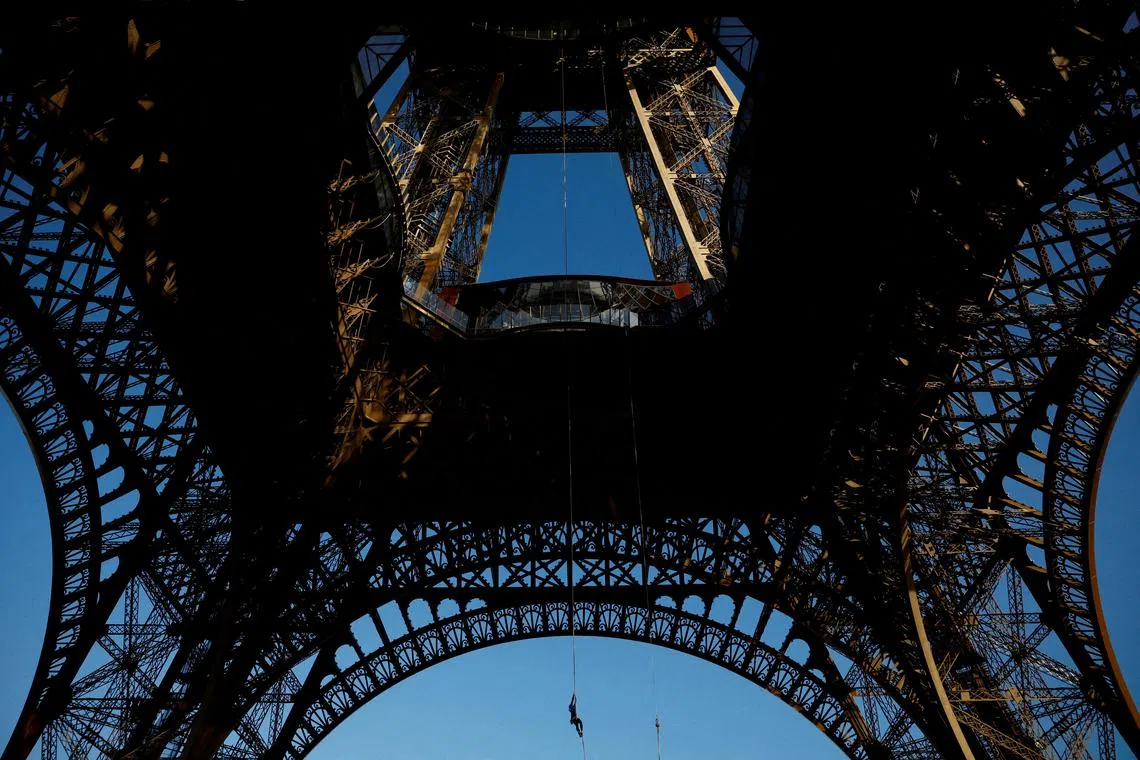 Athlete Anouk Garnier climbing a 110-metre-long rope, launched in the center of the Eiffel Tower square, in an attempt to break the world record for rope climbing, in Paris, France, on April 10, 2024. 