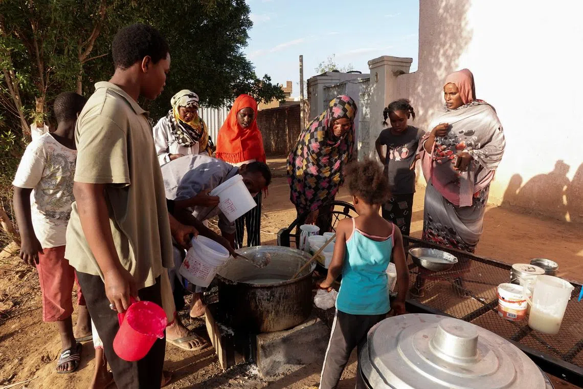 FILE PHOTO: Displaced Sudanese families wait to receive food from a charity kitchen, as a year of war between Sudan's army and the paramilitary Rapid Support Forces (RSF) has driven more than 8.5 million people from their homes, in the city of Omdurman, Sudan, April 6, 2024. REUTERS/El Tayeb Siddig/File Photo
